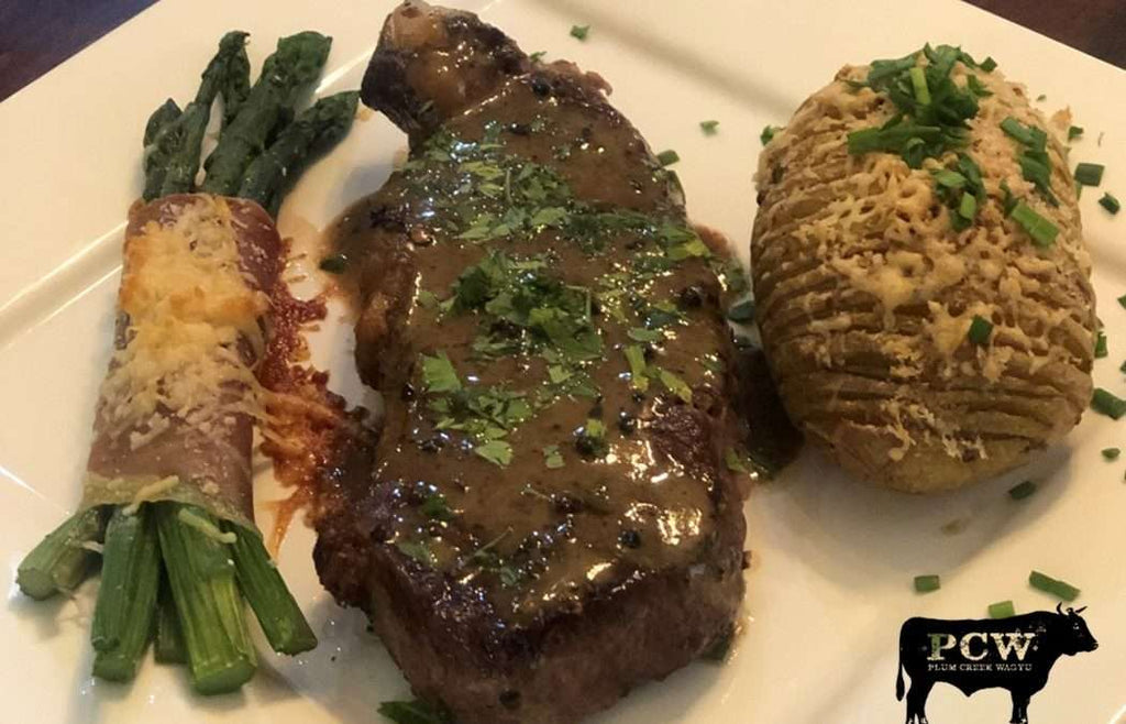 New York Strip Steak au Poivre with Hasselback Potatoes & Prosciutto-wrapped Asparagus Bundles