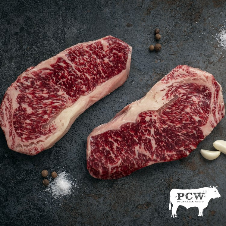Pair of Wagyu Beef New York Strip Steaks with Black Background